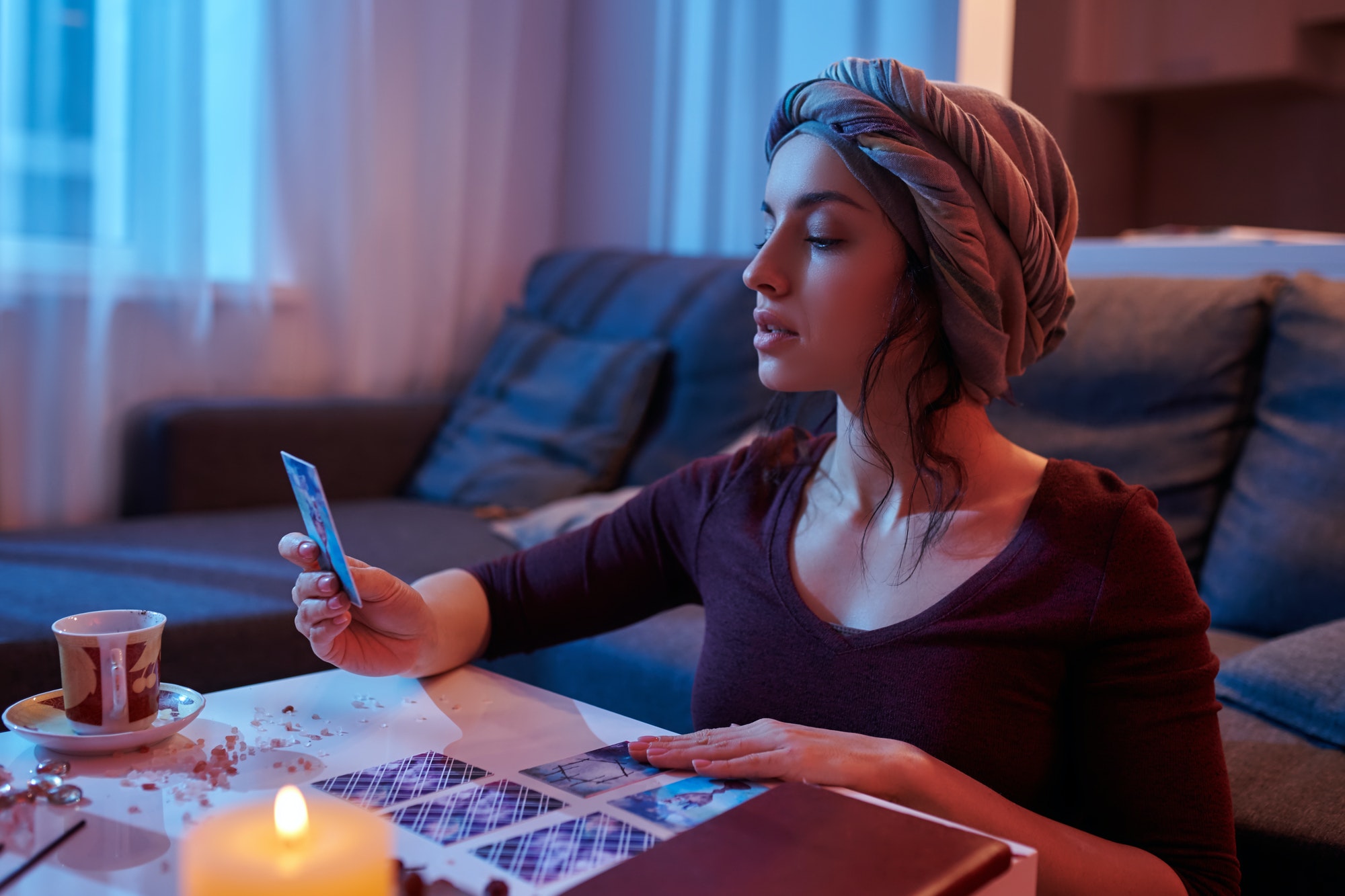 Female soothsayer concentrated on Tarot card reading